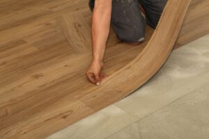Worker installing LVT flooring.