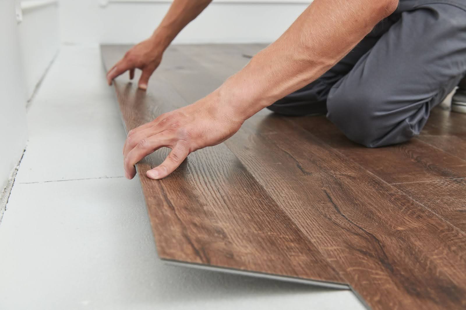 Worker Installing Laminate on Concrete